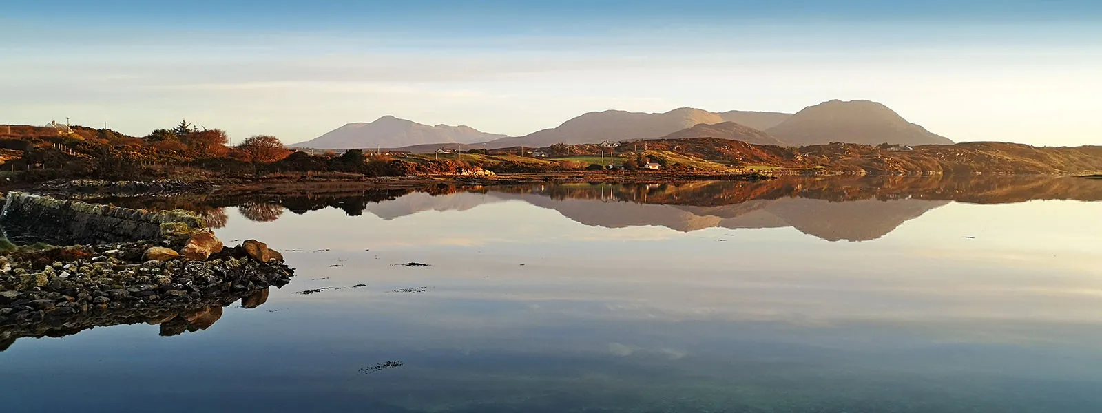 Wide angle view of Ballinakill Bay, Connemara with the mountain landscape reflected in the water.