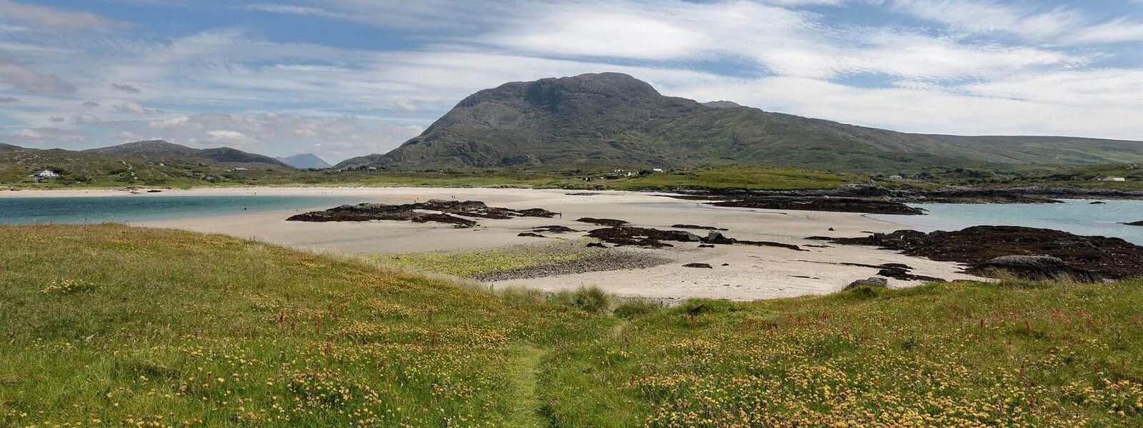 The Beach at Ballinakill Bay with the mountain landscape on a sunny day.