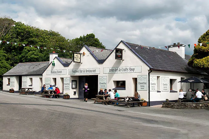 Wide angle view of Clover Fox Restaurant, Letterfrack, Connemara, with diners and waitress outside. wp-image-1219