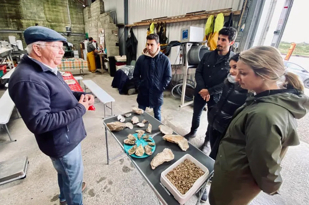 David Keane of DK Connemara Oysters discusses oysters with a small tour group in the farm shed. wp-image-1387