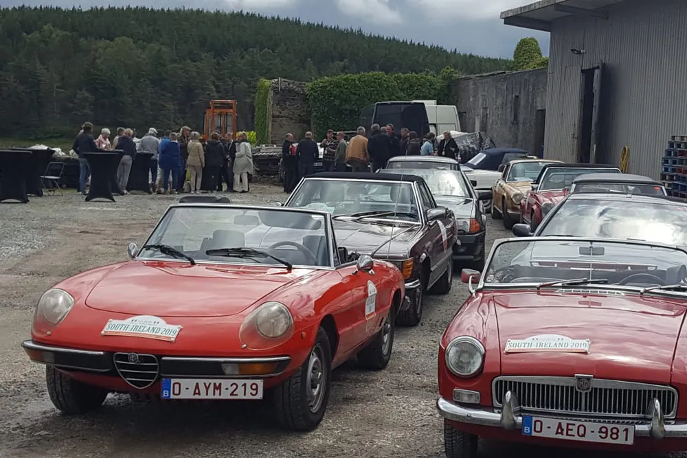 A line-up of vintage cars at DK Connemara Oysters, with the Tour group in the background. wp-image-1392